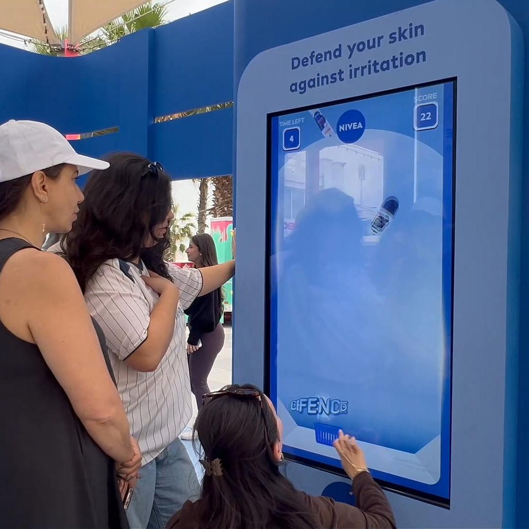 Guests playing the interactive Catch and Dodge game at a Niveae event in Dubai. Custom branded screen with data capture for exhibition marketing